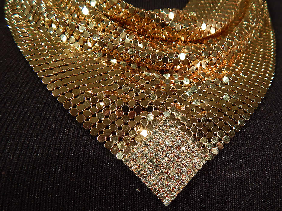 Vintage Whiting & Davis Gold Metal Mesh Rhinestone Bib Necklace Scarf Collar
This beautiful bib necklace has a scarf collar style with a draping cowl front neckline and adjustable chain link strap hook clasp closure on the back neck. There is no label, but was created using Whiting and Davis metal mesh. 