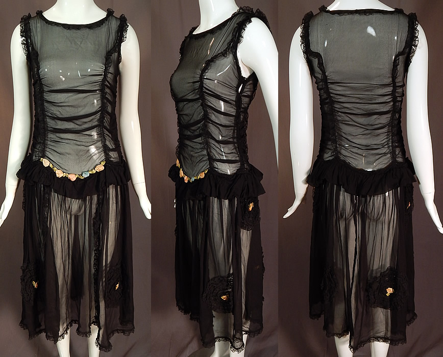 Vintage Ruched Black Silk Chiffon Lace Pink Rosette Trim Drop Waist Dress
This vintage ruched black silk chiffon lace pink rosette trim drop waist dress dates from the 1920s. It is made of a black sheer silk chiffon fabric with ruched gathering along the top, black lace trim edging around the neckline, armholes, skirt rosette medallions. 