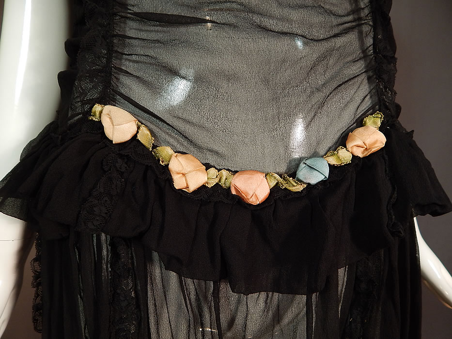 Vintage Ruched Black Silk Chiffon Lace Pink Rosette Trim Drop Waist Dress
This lovely lace dress has a drop waist style, with a ruffled peplum top skirt, sleeveless, side snap closures and is totally sheer, unlined.
