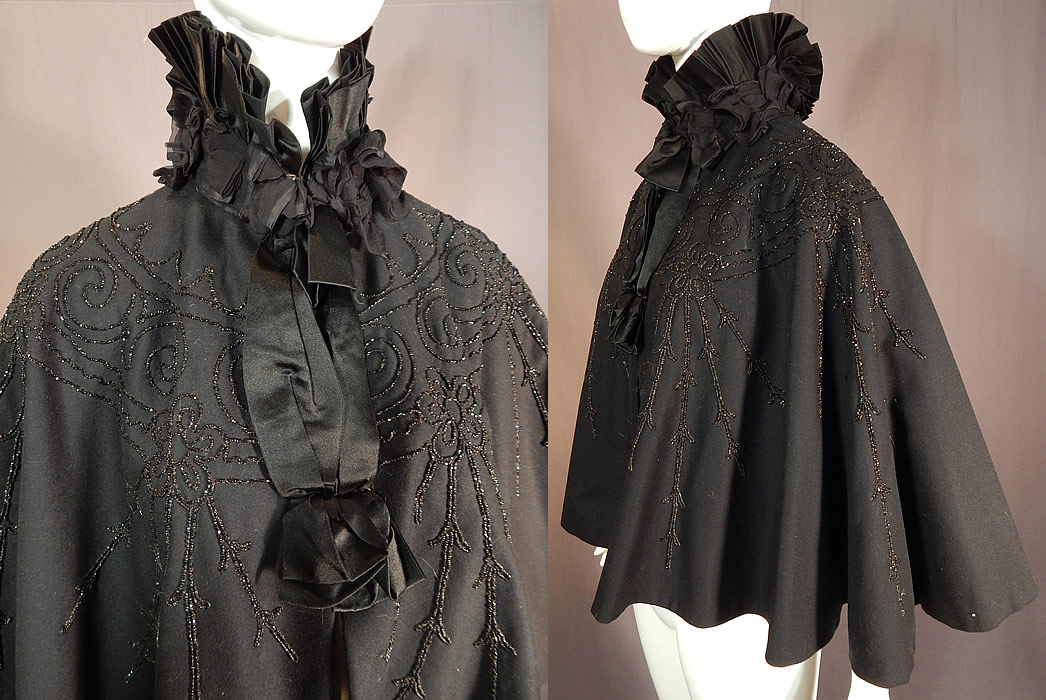 Victorian Black Wool Jet Beaded Pleated Silk High Neck Collar Winter Cloak Cape
This antique Victorian era black wool jet beaded pleated silk high neck collar winter cloak cape dates from 1890. It is made of a black wool fabric, with jet beading done in decorative spiral scrolling, floral vine designs and a black silk pleated high neck collar with black sheer chiffon ruched gathered trim edging. 