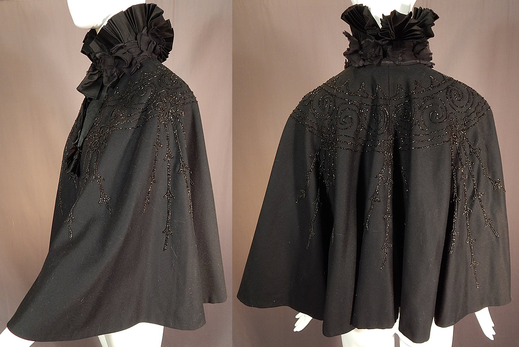 Victorian Black Wool Jet Beaded Pleated Silk High Neck Collar Winter Cloak Cape
This beautiful black beaded winter cloak cape has a dramatic high neck boa pleated stand up collar, silk ribbon bow trim hanging down the front, with hook closures and is fully lined. 