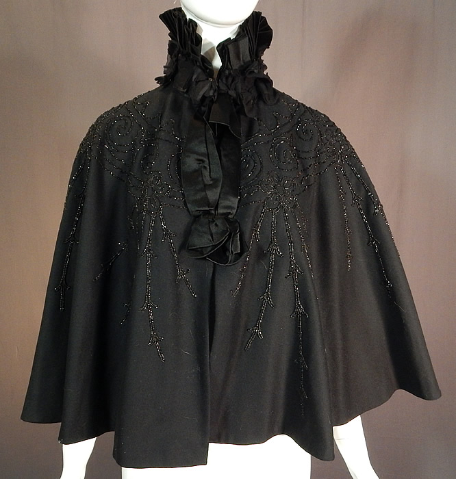 Victorian Black Wool Jet Beaded Pleated Silk High Neck Collar Winter Cloak Cape
The cape measures 21 inches long, 19 inches across the shoulders and has a 15 inch neck. 