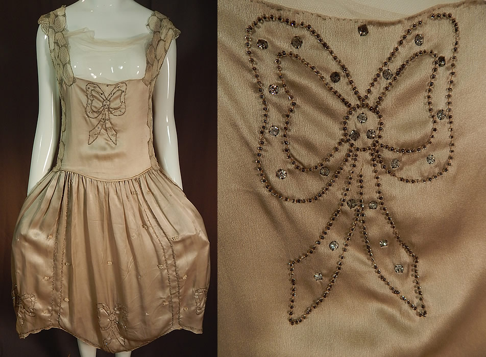Vintage Gray Silk Rhinestone Silver Beaded Bow Handkerchief Hem Flapper Dress
It is made of a light gray silvery sheen silk fabric with rhinestone, silver beadwork down in a bow design, with pearl beaded accents and silver metallic, white embroidered net trim along the shoulders, sides and neckline. 