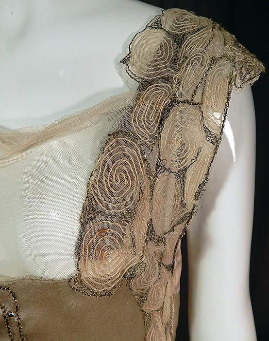 Vintage Gray Silk Rhinestone Silver Beaded Bow Handkerchief Hem Flapper Dress
The dress measures 42 inches long, with a 32 inch bust and 28 inch waist. It is in good as-is condition, with a few faint small stains on the front top and has been altered, restored with the shoulder straps reinforced, added tulle net along the front neckline (see close-up). 