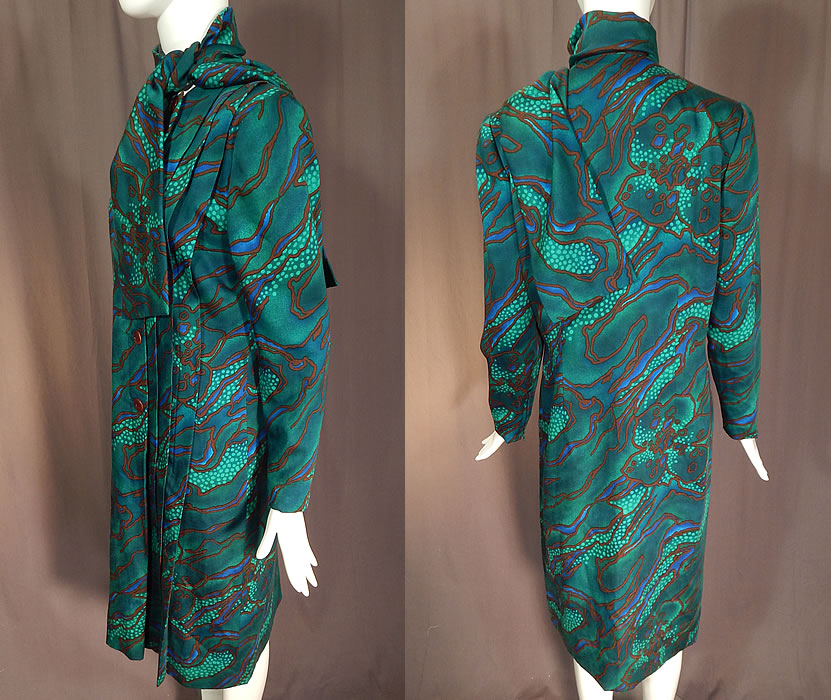 Vintage Pauline Trigere Green Abstract Stained Glass Floral Print Neck Scarf Dress
This delightful designer dress has an attached neck scarf, shoulder padding, long tapered sleeves with zipper closure cuffs, pleating along the side opening, with button closures and is fully lined.