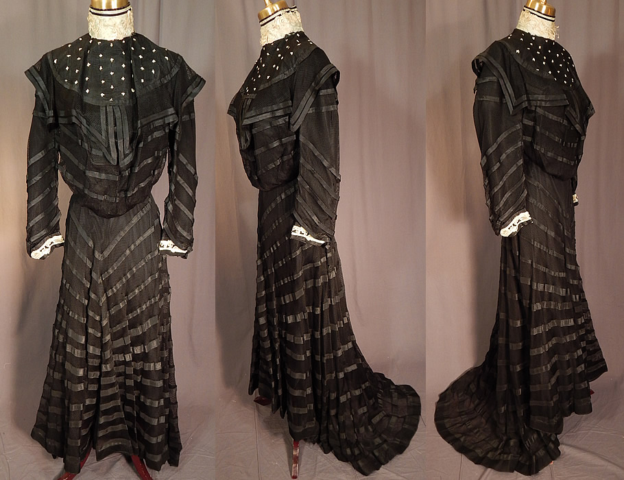 Victorian Black Mesh Net Silk Ribbon Stripe Gown Bodice Skirt Train Dress
This antique Victorian era black mesh net silk ribbon stripe gown bodice skirt train dress dates from 1900. It is made of a sheer black mesh net fabric, with black silk stripe decorative trim appliqu&eacute; accents. There is blue chenille embroidered tiny crosses on the yoke, a blue silk ribbon, white lace appliqu&eacute; trim collar and cuffs. This magnificent gown two piece dress has a pouter pigeon front bodice blouse top with a high neck collar, layered mesh net overlay on the shoulders, long full sleeves, hook closures down the back and is lined is fully lined with stays boning inside. The bodice measures 17 inches long, with a 32 inch bust, 26 inch waist, 21 inch long sleeves and 12 inch neck.