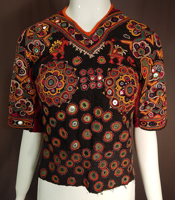 Vintage Indian Gujarati Kutch Work Embroidered Mirror Choli Boho Blouse Top
This vintage antique Indian Gujarati kutch work colorful embroidered mirror choli boho blouse top dates from the early 1900s. It is hand stitched, made a hand dyed black, red cotton twill fabrics with vibrant colorful decorative crewel chain stitch kutch work embroidery done in the tribal folk patterns from Gujarati, Rajasthan India and Sindh Pakistan.