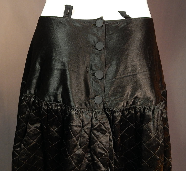 Victorian Antique Black Silk Quilted Wool Winter Petticoat Skirt
This beautiful black winter petticoat has a long floor length full skirt, a fitted wide drop waist with black silk button closures on the back and button hole strap tabs at the top and is fully lined with brown cotton fabric inside the top, worsted wool fabric underneath and velvet trimming the inside hemline.