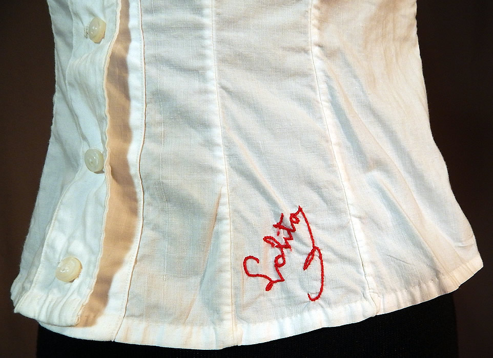 Victorian Lolita Lingerie White Cotton Lace Trim Camisole Corset Cover Top
This antique Victorian era Lolita lingerie white cotton lace trim camisole corset cover top dates from 1890. It is made of a white cotton fabric, with lace trim edging the armholes. There is a turkey red work hand embroidered stitched monogrammed name "Lolita" on the bottom front. 