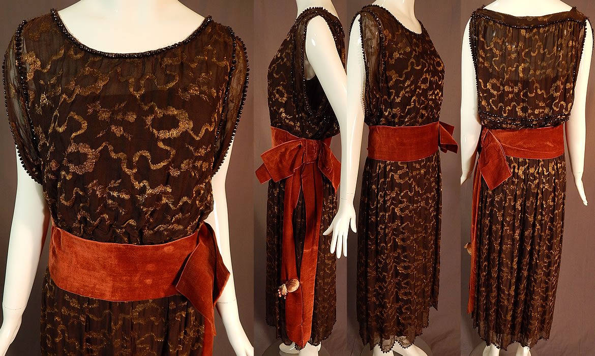 Vintage Art Deco Brown Silk Gold Lame Beaded Belted Flapper Dress Lam&eacute;
There is an burnt orange rust color velvet ribbon sash belt with side bow and colorful silk velvet grape berry leaf fruit trim three dimensional appliqu&eacute;d near the bottom end. This fabulous flapper style dress a layered sleeveless top, an attached belted ribbon sash waist, a fitted waistband with inner, outer side snap closures and is fully lined in a brown silk fabric.