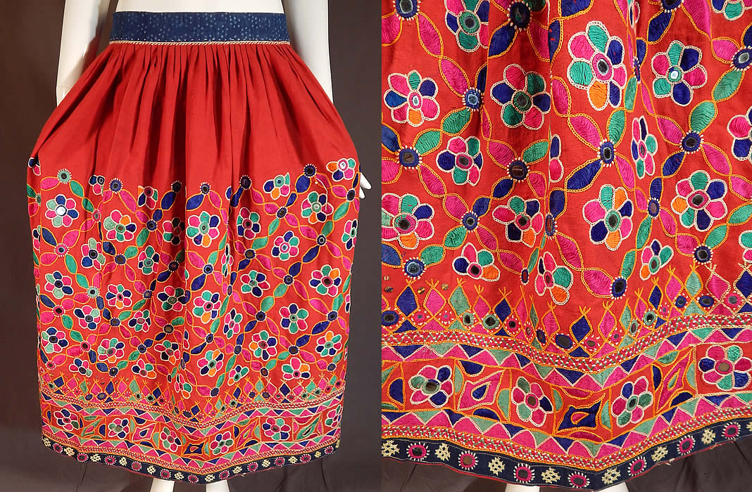 Vintage Afghanistan Ahir Banjara India Ghagra Kutch Mirrorwork Embroidery Skirt
This vintage Afghanistan Ahir Banjara India ghagra kutch mirrorwork embroidery skirt dates from the 1970s. It is made a red cotton fabric with hand sewn bright colorful kutch embroidery work, chain stitching, satin stitching and buttonhole stitching surrounding small glass mirrors creating an ethnic floral design.