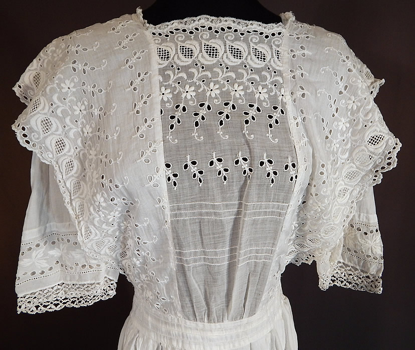 Vintage Edwardian White Cotton Broderie Anglaise Eyelet Embroidery Girls Dress
This lovely lace girls youth dress is a shorter mid length, with a ruffle flounce trim over the shoulders, a squared front neckline, 3/4 length sleeves, a fitted waistband, button closures down the back and is sheer, unlined.