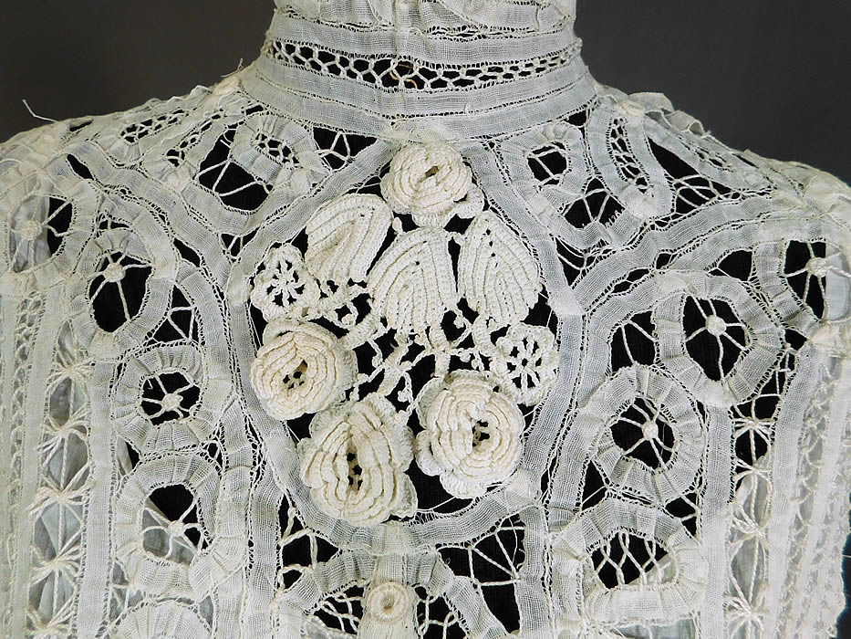 Victorian White Battenburg Tape Lace Crochet Trim Bodice Blouse Top
This antique Victorian era white battenburg tape lace crochet trim bodice blouse top dates from 1900. It is made of a white sheer hand made battenburg tape lace with connecting thread picot ornamented bars, buttonhole stitches, decorative pinwheel spiral, scrolling, striped designs and Irish crochet raised three dimensional trim flowers, leaves on the front yoke. 