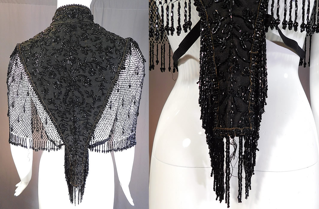 Victorian Black Silk Jet Beaded Fringe Mesh Mantle Dolman Pelerine Cloak Cape
This stunning short cloak cape capelet has a dolman pelerine mantle style with a sheer meshwork woven net sides, long beaded fringe ends, a high band collar with hook closures down the front, inner straps around the waist and is unlined.