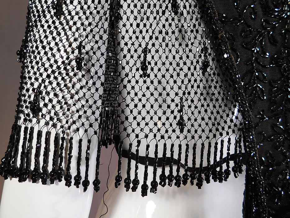 Victorian Black Silk Jet Beaded Fringe Mesh Mantle Dolman Pelerine Cloak Cape
It is in good as-is condition, needing some restoration with some loose missing beads, fringe trim along the bottom edging and the silk fabric lining inside was shattered, removed with remnants remaining (see close-ups). This is truly a wonderful piece of antique Victoriana mourning beaded art! 