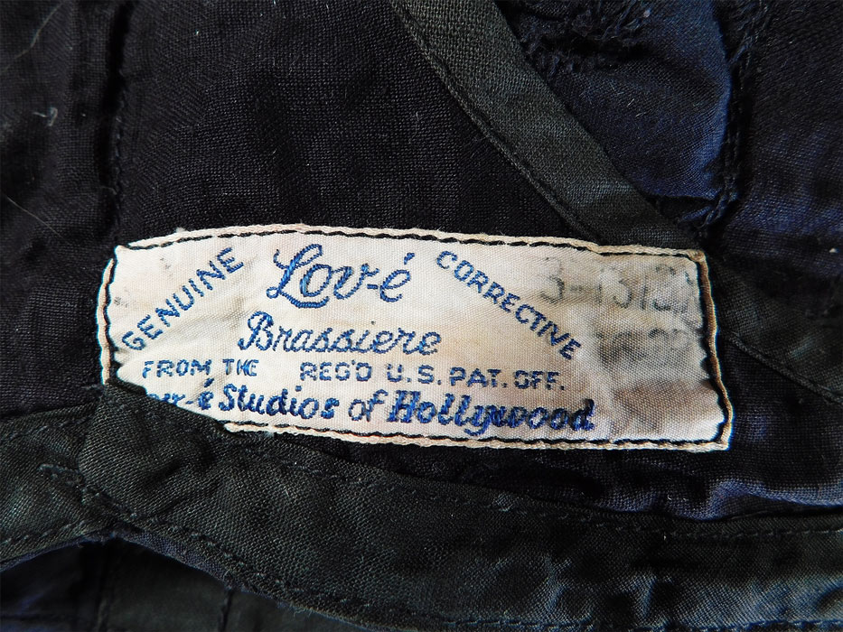 Vintage Lov-e Studios of Hollywood Brassiere Black & Blue Eyelet Corrective Bra
There is a "From The Lov-e Studios of Hollywood Genuine Corrective Brassiere" label, size 32-36 tag sewn inside.