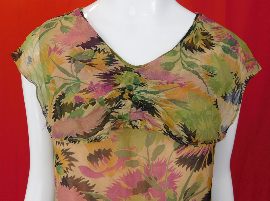 Vintage Floral Pastel Print Silk Chiffon Smocking Shawl Collar Drop Waist Dress
This vintage floral pastel print silk chiffon smocking shawl collar drop waist dress dates from the 1920s. It is made of a silk chiffon fabric with pastel color floral print design and smocking gathers.