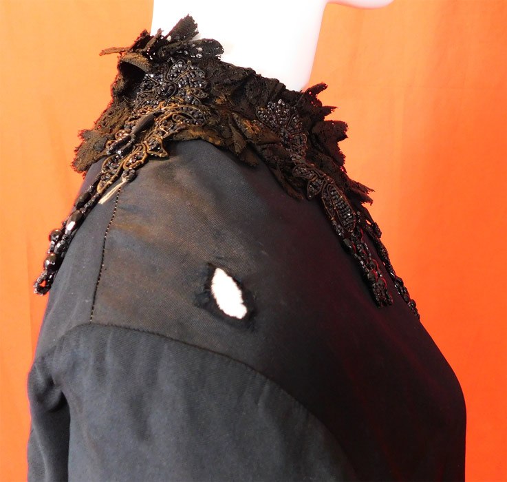 Victorian Black Silk Jet Beaded Fringe Tassel Trim Dolman Mantle Cloak Cape
It is in fair as-is condition, needing some restoration, with several small frays, splits scattered on the silk fabric, a small frayed hole on the shoulder, some discoloration fading on the black lace collar trim and some loose, missing beads (see close-ups). This is truly a wonderful piece of antique Victoriana wearable art! 