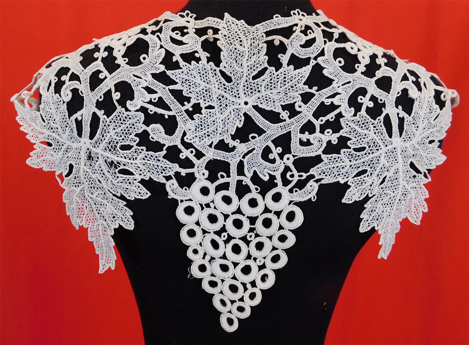 Victorian Antique Gros Point de Venise Grapes Vine Leaf Needlepoint Lace Collar Trim
This lovely lace collar dress trim has cascading bunches of grapes draping down the front lappet point ends, shoulders and back, with cutwork grape leaves, an open front with no closure and is sheer, unlined. 