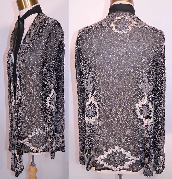 Vintage Art Deco Black Silk Chiffon White Beaded Flapper Evening Coat Jacket. his fabulous flapper, exquisite evening coat is a long mid length, loose fitting, with long full sleeves, a black silk neck tie scarf sash, beaded lappet bottom ends hanging down the front, an open front with no closure and is sheer, unlined. 