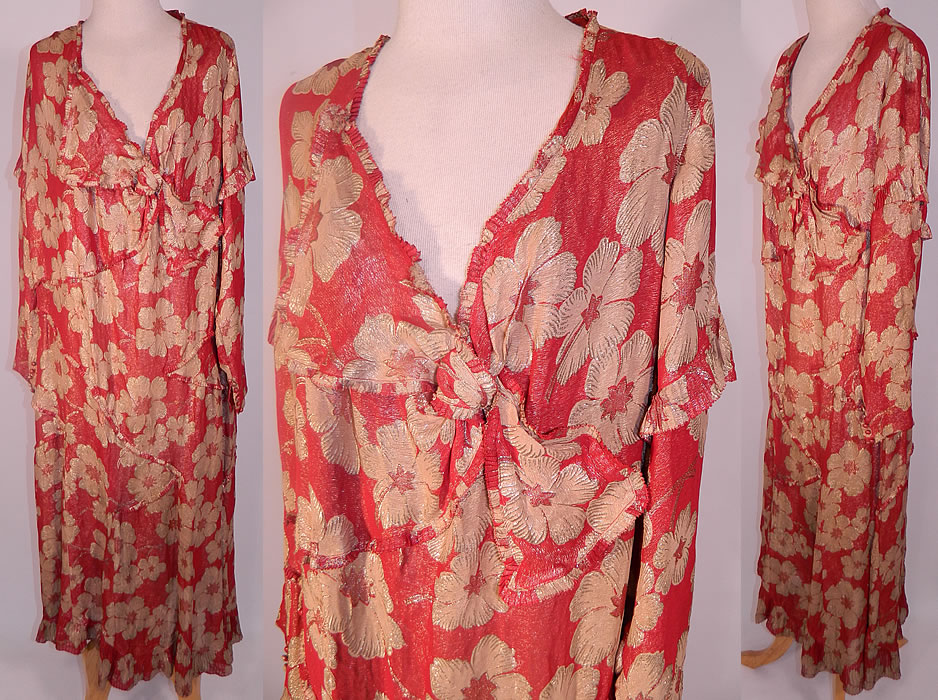 Vintage Art Deco Red Silk Gold Lam&eacute; Floral Poppy Drop Waist Dress Large Size. It is made of a reddish orange color silk lam&eacute; fabric, with gold metallic threads woven through it creating a floral poppy pattern. This fabulous flapper dress is loose fitting, with a drop waist, long sleeves with button cuffs, an asymmetrical knotted trim V neckline with pleated ruffle trim edging and a long mid length skirt.