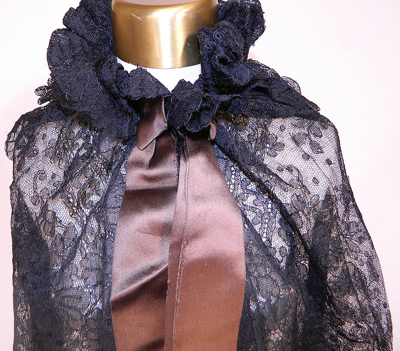 Victorian Antique Black Chantilly Lace Layered Shawl Cloak Cape. This lovely lace cloak cape was created from a shawl, with a layered tiered back, gathered ruffle neck collar with hook closure, brown silk satin ribbon bow trim and is sheer, unlined. The cape measures 32 inches long in the front, 22 inches long in the back, with a 50 inch bust, 18 inch neck and 110 inch bottom circumference.