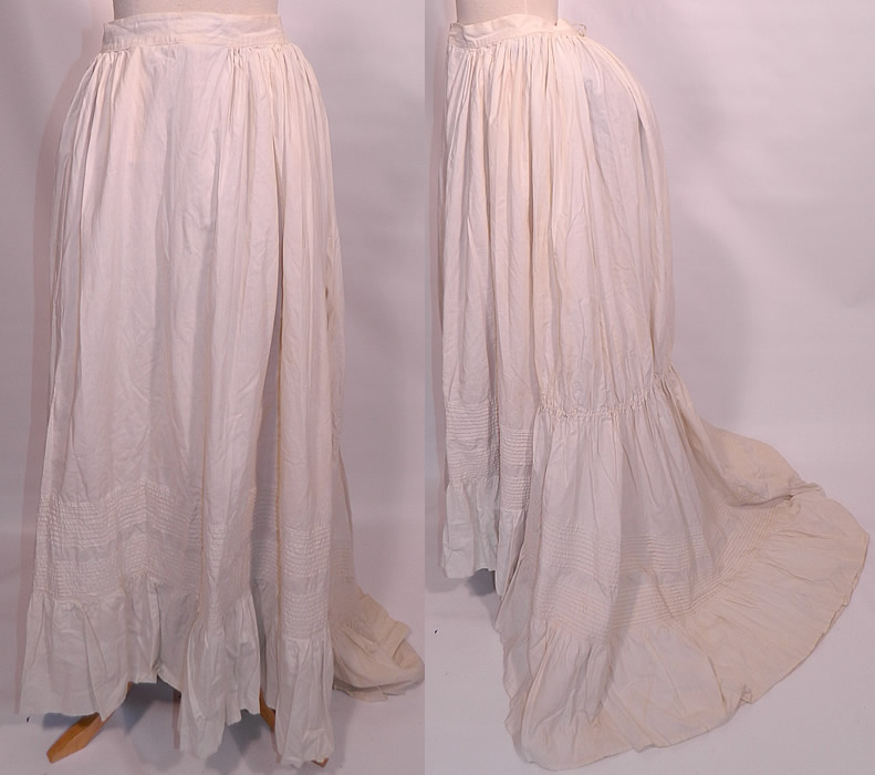 Victorian Pleated White Cotton  Bustle Back Train Bridal Wedding Petticoat Skirt. This antique Victorian era pleated white cotton bustle back train bridal wedding petticoat skirt dates from the 1870s. It is made of a white cotton fabric, with pleating along the bottom and a layered ruffle hemline. 