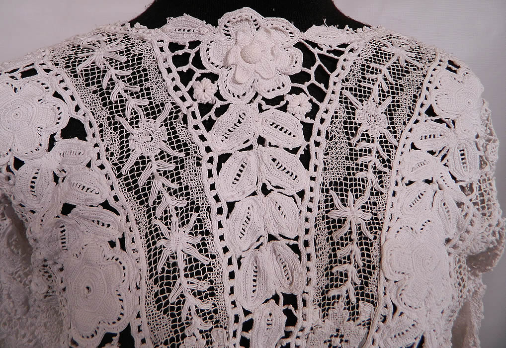 Edwardian Antique White Irish Crochet Tape Lace Bodice Blouse. There is a patchwork of various styles of handmade laces and techniques. This lovely lace beautiful bodice blouse top has a three dimensional flower neckline, 3/4 length sleeves with crochet ball fringe trim cuffs, a linen waistband and open back with no closure. 