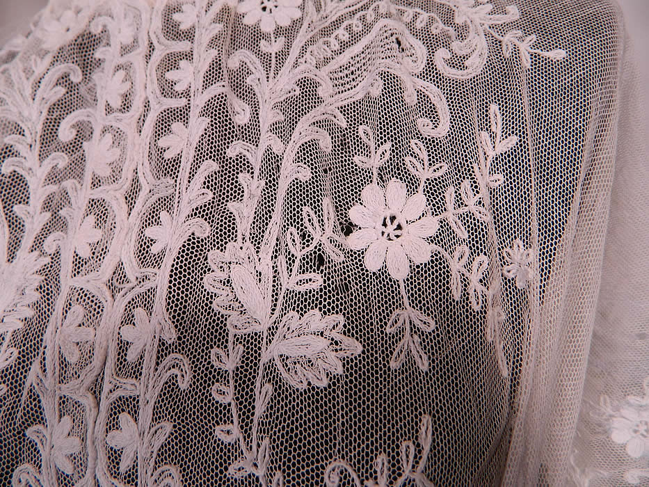Edwardian White Net Tambour Embroidery Lace Silver Rosette Belted  Dress. It is sheer and unlined. The dress measures 60 inches long, with 34 inch hips, a 24 inch waist and 34 inch bust.