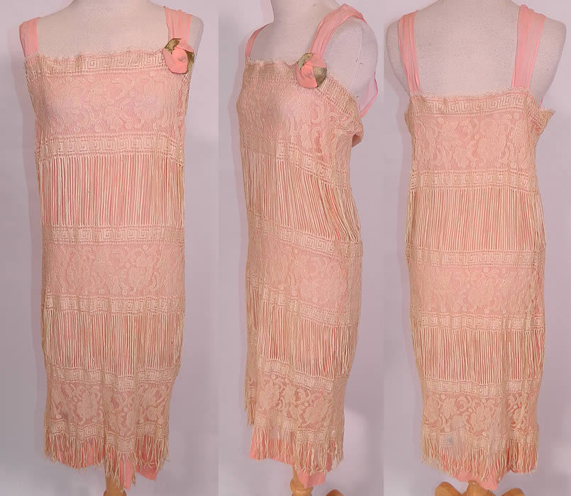 Vintage Cream Fringe Filet Lace Pink Silk Rosette Chemise Slip Flapper Dress. This exquisite vintage cream fringe filet lace pink silk rosette chemise slip flapper dress dates from the 1920s. It is made of a pale pink silk chiffon slip lining underneath, with an off white cream color sheer fine unique fringed filet lace floral pattern fabric overlay.