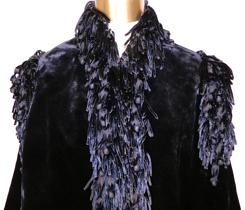 Victorian Black Velvet Chenille Beaded Fringe Winter Dolman Mantle Cape. This magnificent winter dolman mantle style cape has fringe trim around the collar, shoulders, sleeve cuffs, front opening, bottom, hooks for closure down the front and is fully lined in a fine black wool fabric with inside pocket and tie waistband.