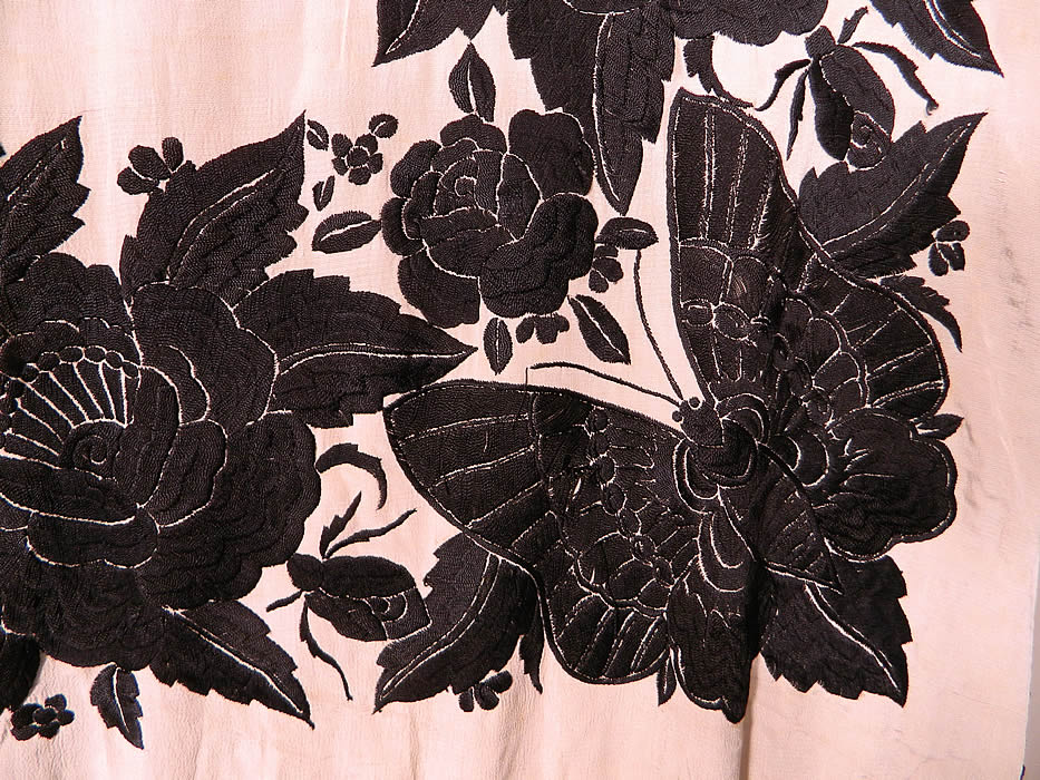 Antique Black & White Floral Butterfly Silk Embroidered Canton Piano Shawl. There is a fabulous floral rose, dragonfly embroidered border with a large beautiful butterfly embroidered in each corner. There is a hand knotted macram&eacute; black silk fringe which measures 24 inches long surrounding the entire shawl with rounded corners.