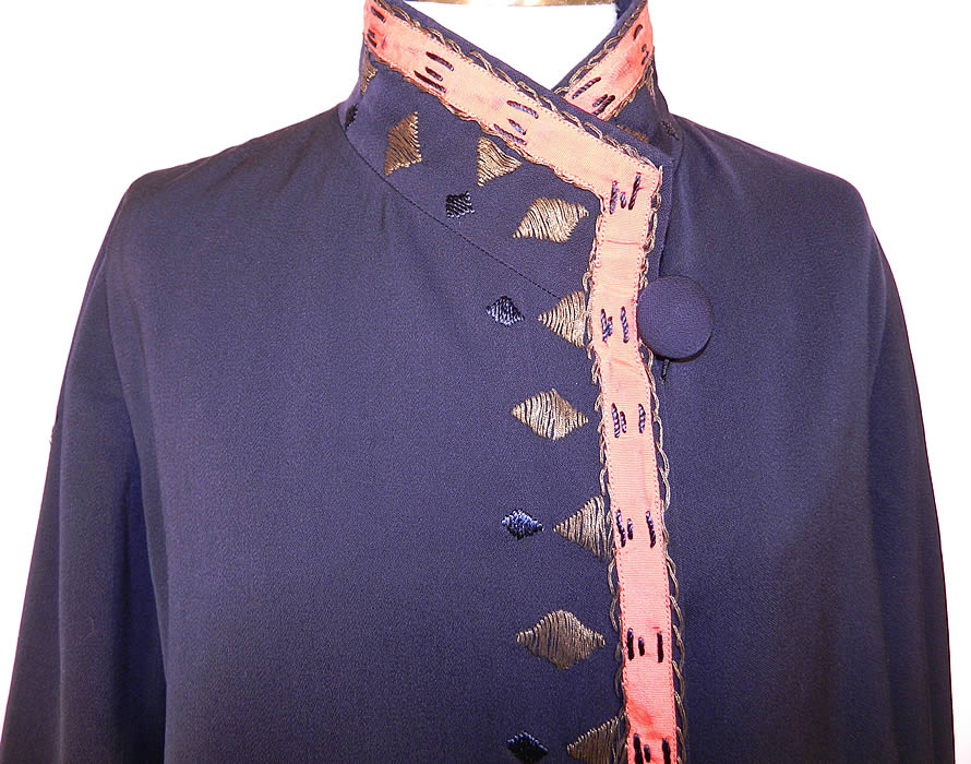 Vintage Art Deco Navy Blue Wool Gabardine Gold Lam&eacute; Embroidered Flapper Coat. This fabulous flapper evening coat has a band coat uniform style, is a long floor length, loose fitting, with a high neck collar, button closure, long full sleeves and is fully lined in a red silk fabric with inside pocket and a "Gano Downs Denver" department store label sewn inside. 
