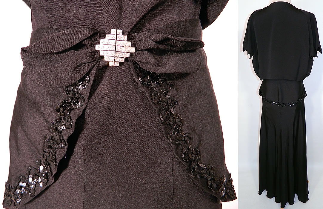 Vintage Black Silk Crepe Belted Peplum Skirt Bolero Jacket Bias Cut Dress Evening Gown. This two piece elegant evening gown ensemble includes a long floor length bias cut dress with shoulder strap ties, a plunging V front neckline, backless, with an attached sequined trim belted peplum drape short overskirt and rhinestone buckle clasp closure on front.