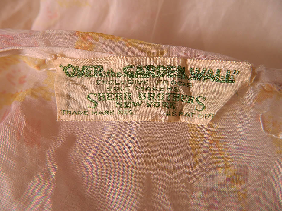 Vintage Over The Garden Wall Pink Roses  White Organdy Ruffle Shawl Collar Bias Cut Dress. There is an "Over the Garden Wall Exclusive Frocks Sole Makers Sherr Brothers New York" label sewn inside. The dress measures 50 inches long, with 40 inch hips, a 30 inch waist and 36 inch bust. It is in good clean condition. This is truly a wonderful piece of wearable art.