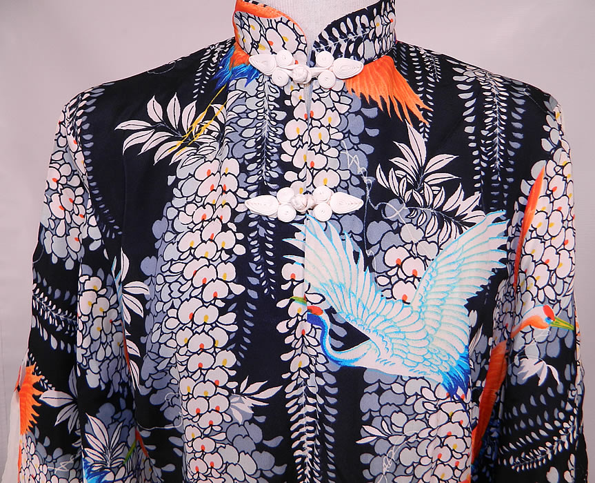 Vintage Lauhala Hawaiian Cranes Print Rayon Pake MuuMuu Dress. It is made of a rayon fabric with a black background and a Hawaiian print with white ginger flowers and colorful crane birds in flight. 
