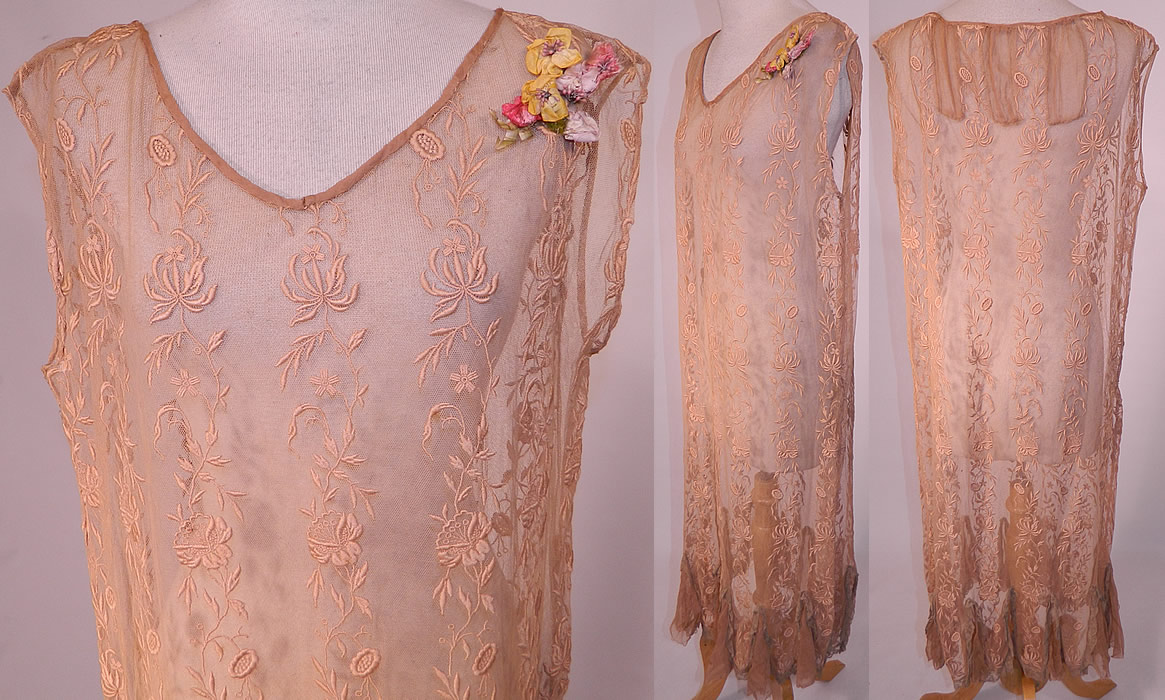 Vintage Ecru Embroidered Net Lace Silk Rosette Chemise Shift Slip Dress. 
There is a pastel silk ribbon rosette flower trim on the shoulder. This lovely lace chemise shift style slip dress is loose fitting, sleeveless, with sheer silk chiffon inserts on the back neck, along the bottom lace trim flared handkerchief hemline skirt and is sheer, unlined. 