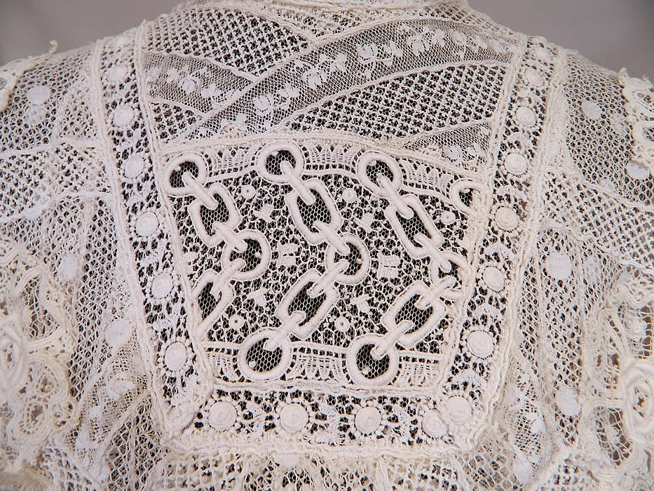 Edwardian Belle Epoque White Mixed Lace Purple Ribbon Skirt Wedding Gown Dress
This lovely lace dress is a long floor length, with a high neck lace collar, layered yoke top, long sleeves, a full bottom skirt, hook closures down the back and is sheer, lined in a net fabric. 