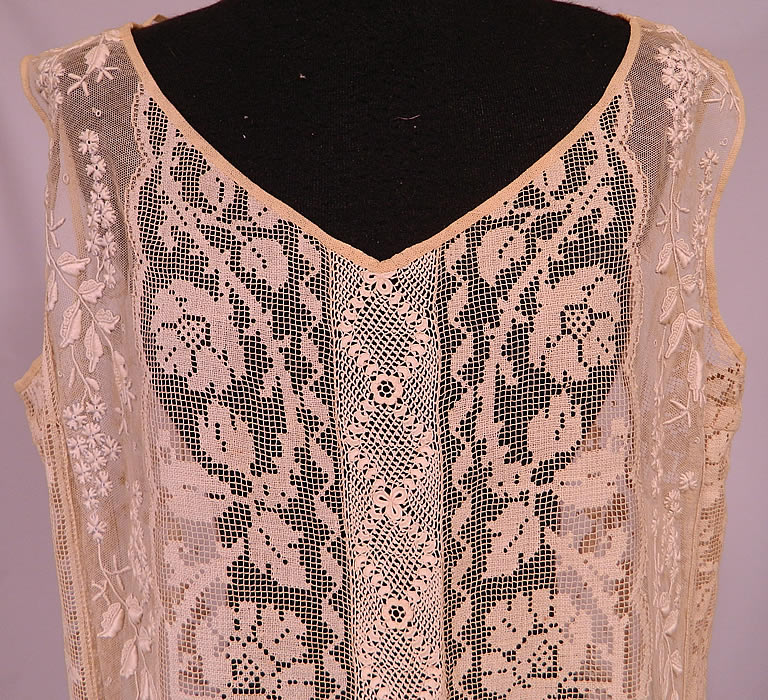Vintage Embroidered French Knot Net Irish Crochet Filet Lace Chemise Drop Waist Dress
It is made of an off white cream color sheer net fabric with raised padded satin stitch, French knot embroidery work done in a forget-me-not floral vine leaf design, filet lace roses and Irish crochet lace trim down the front & back.