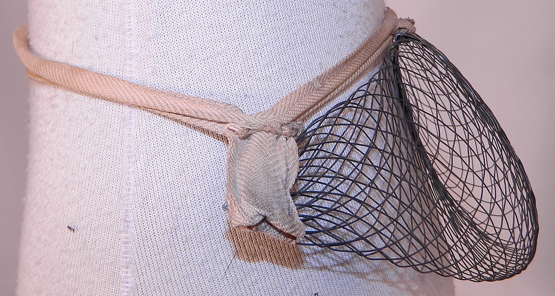 Victorian Antique Woven Wire Mesh Pillow Crescent Crinolette Bustle Pad Support
There is a linen cloth strap waistband belt with adjustable buckle closure front. This unique undergarment would have been worn under a bustle skirt dress to expand the fullness or support the back drape of the fanned train skirt. 