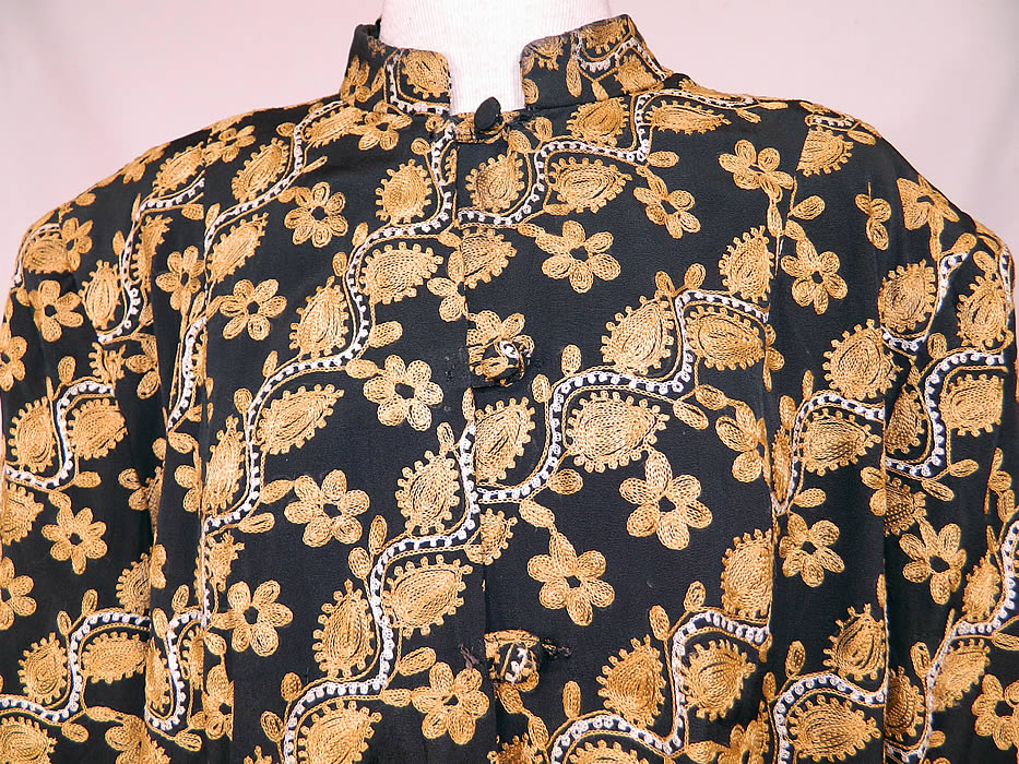Vintage Black Silk Rayon Chain Stitch Crewel Work Embroidery Swing Coat Jacket.
This exquisite ethnic Indian inspired loose fitting boxy swing coat jacket is a long mid length, with broad shoulder padding, long full sleeves, an embroidered mandarin band collar, fabric buttons for closure down the front and is fully lined.