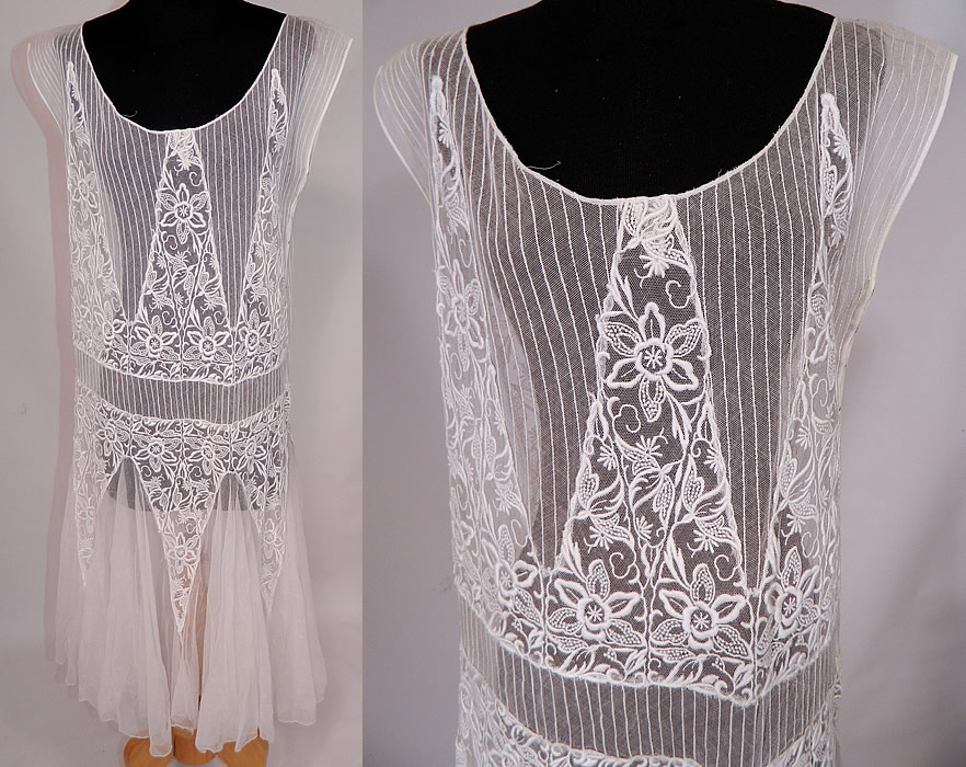 Vintage White Embroidered Pleated Tulle Net Lace Chemise Drop Waist Dress
This vintage white embroidered pleated tulle net lace chemise drop waist dress dates from the 1920s. It is made of a white sheer net lace fabric with striped pleating and raised padded satin stitch embroidery work done in a floral vine leaf, sawtooth wave design. 