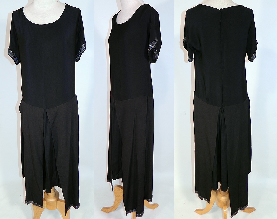 Vintage Art Deco Black Silk Crepe de Chine Tiered Panel Skirt Beaded Flapper Dress
This Art Deco vintage black silk crepe de chine tiered panel skirt beaded flapper dress dates from the 1920s. It is made of a black silk crepe de chine fabric, with a silver steel color beaded trim on the sleeve cuffs and bottom skirt panels. 