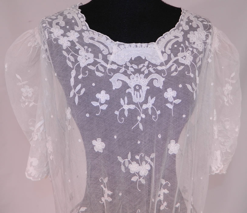 Vintage White Tambour Embroidery Lace Sheer Silk Tulle Net Drop Waist Dress
This lovely lace drop waist dress is loose fitting, with a scalloped neckline, gathered shoulders with woven crinoline padding, short puffy sleeves, a decorative embroidered waist, side snap closures and is sheer because it is unlined.