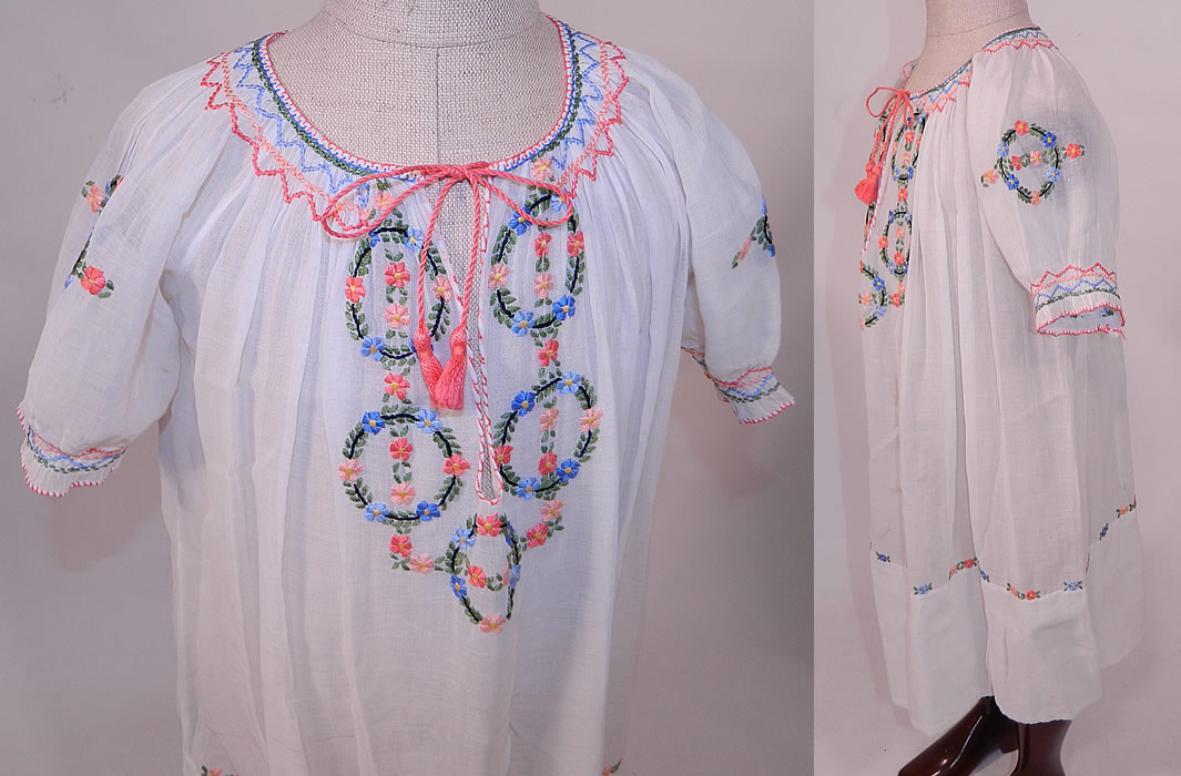 Vintage Childs White Cotton Colorful Embroidered Smocking Hungarian Peasant Dress
This pretty peasant style bohemian Hungarian little girls dress has a loose fitting shift style, with short sleeves, a drawstring front neckline, smocking around the neck, sleeve cuffs and is sheer, unlined. 
