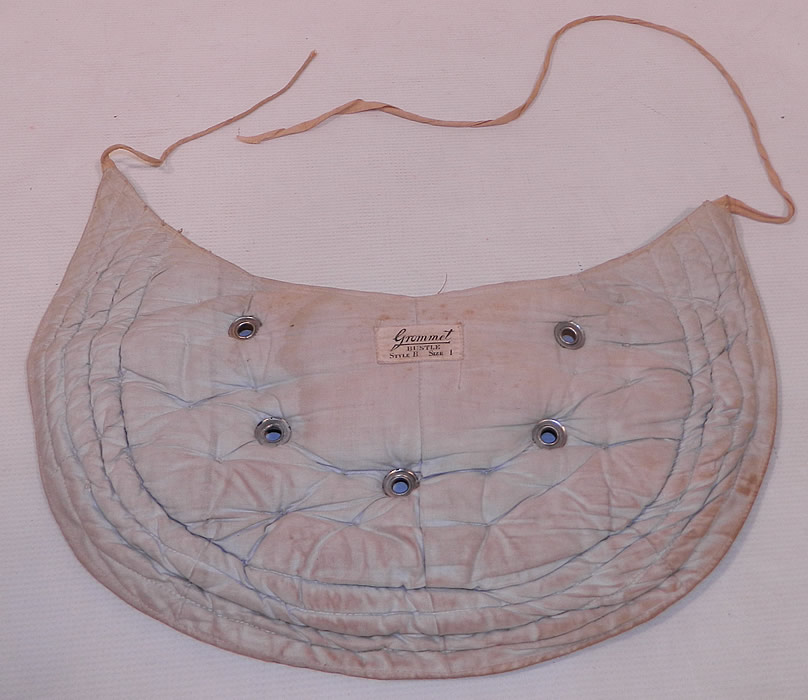 Victorian Antique Grommet Bustle Quilted Cotton Pad Pillow Crescent Crinolette
The bustle pad is a large size measuring 15 1/2 inches wide, 8 1/2 inches long, with a 53 inch adjustable waist tie. It is in good condition, with only some minor wear and soiling. This is truly a rare and wonderful piece of wearable Victoriana art! 