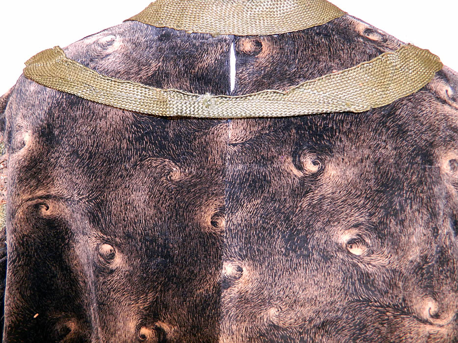 Edwardian Black Velvet Gold Print Peacock Hurricane Eye Cyclone Coat
The coat measures 33 inches long, with 60 inch hips, a 60 inch waist, 50 inch bust and 21 inch long sleeves. It is in good as-is condition, with a small fray on the front top insert, back neck seam and several brown stains, with frayed holes on the cream silk sleeve lining (see close-ups). This is truly a wonderful piece of wearable textile art! 