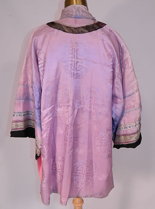 Antique Chinese Character Embroidered Purple Lilac Silk Damask Brocade Robe
This lovely lilac Manchu womens robe is a short mid length, has a mandarin collar, decorative black silk appliqu&eacute; front with pink knotted trim edging, replaced newer buttons with loop toggle closures, long full sleeves and has been relined in a pink cotton fabric. 