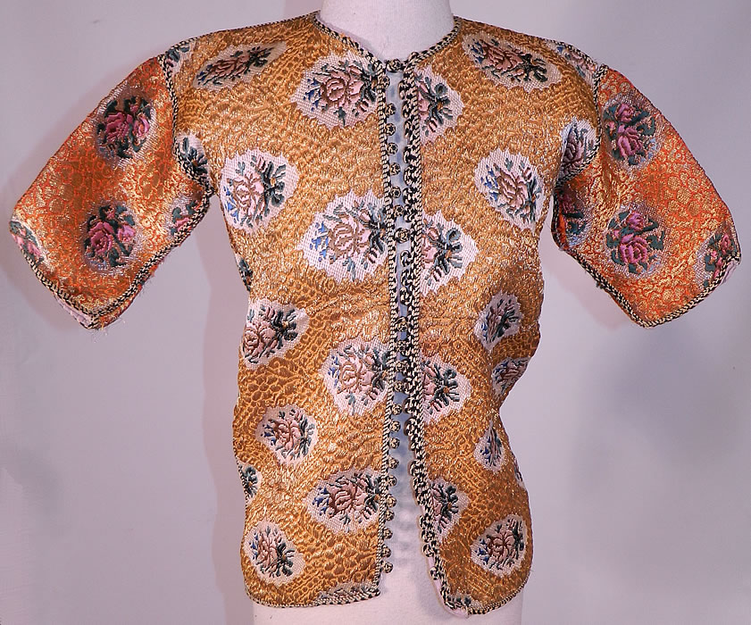Antique Bukhara Uzbekistan Gold Lam&eacute; Lame Brocaded Childs Chapan Coat
This antique Bukhara Uzbekistan gold lam&eacute; brocaded child's chapan coat dates from the 1920s. It is made of a beautiful brocaded fabric woven with heavy gold lam&eacute; metallic thread and colorful silk threads creating a fabulous floral roses, raised textured weave pattern design. 