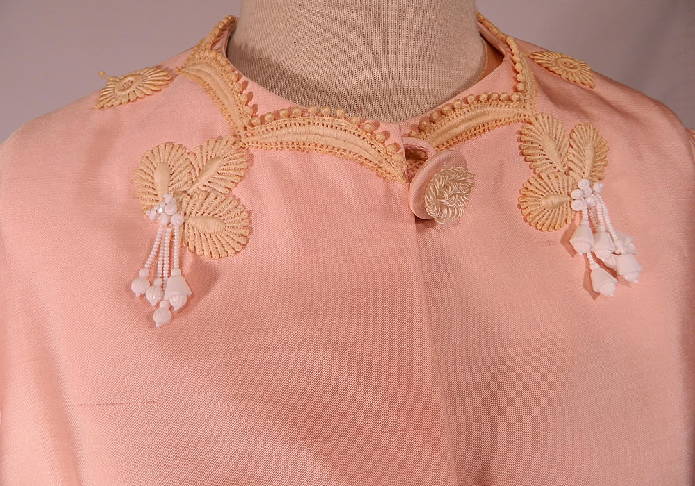 Vintage Haute Couture Athens Label Pink Raw Silk Beaded Lace Trim Dress & Jacket
This pretty pink Jackie Kennedy Onassis inspired two piece suit outfit has a short mid length loose fitting boxy coat jacket, with 3/4 length sleeves, decorative fabric covered button closures down the front and is fully lined.